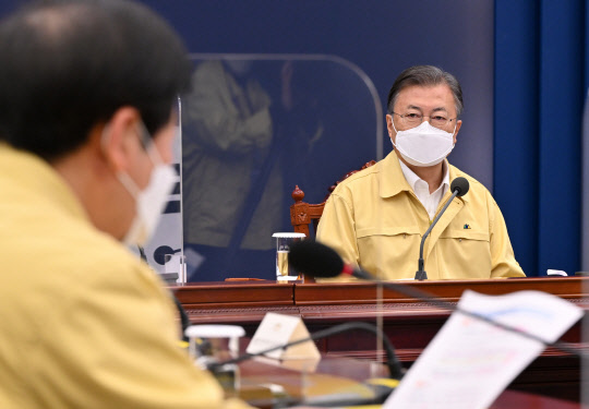 26일 문재인 대통령이 청와대 여민관 영상회의실에서 열린 오미크론 대응 점검회의에서 구윤철 국무조정실장으로부터 보고 받고 있다. 청와대 제공.